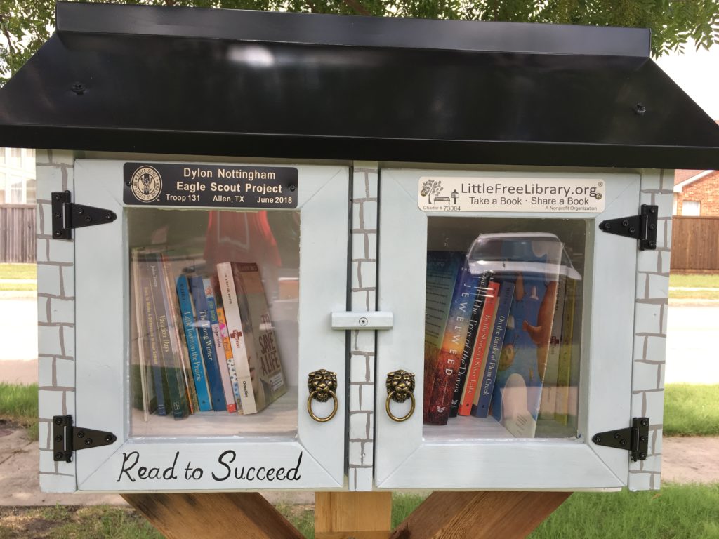 Close up photo of front of library. Features Read to Succeed and lion head with rings door knobs.