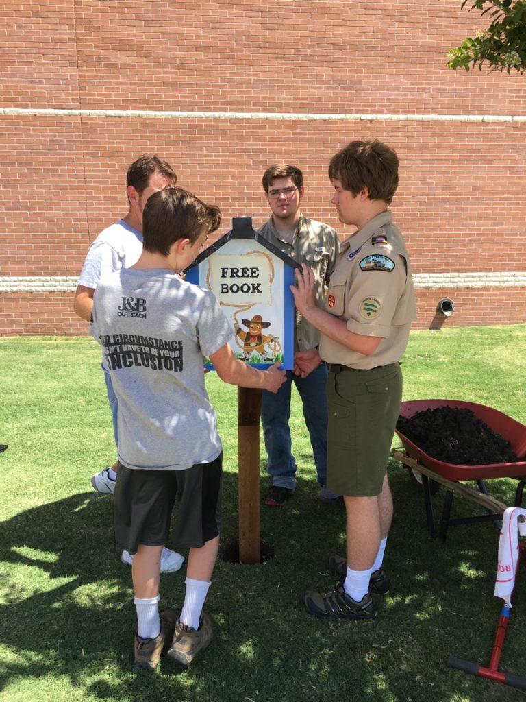 Scouts putting little free library on post at lindsey elementary