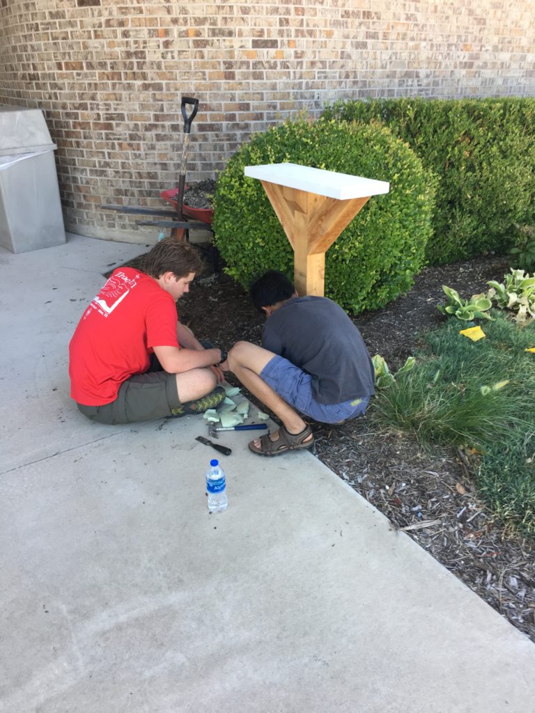 Scouts adding books to the Little Free Library at Alton Boyd Elementary, 